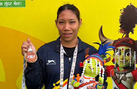 बीमारी से जंग और भाई के अधूरे सपनों को पूरा करने का साहस लिए अरुणाचल की अनाई ने जीता यादगार केआईटीजी स्वर्ण बीमारी से जंग और भाई के अधूरे सपनों को पूरा करने का साहस लिए अरुणाचल की अनाई ने जीता यादगार केआईटीजी स्वर्ण रायपुर, 28 मार्च 2026 बीमारी से जंग और भाई के अधूरे सपनों को पूरा करने का साहस लिए अरुणाचल की अनाई ने जीता यादगार केआईटीजी स्वर्ण खेलो इंडिया ट्राइबल गेम्स के पहले संस्करण के लिए रायपुर रवाना होने से कुछ ही दिन पहले अरुणाचल प्रदेश की 21 वर्षीय वेटलिफ्टर अनाई वांगसु अस्पताल के बिस्तर पर थीं। उनकी पुरानी गैस्ट्रिक समस्या एक बार फिर उभर आई थी और ताकत लौटाने के लिए उन्हें इंट्रावेनस फ्लूइड्स पर रखा गया। ऐसे में उनके इन खेलों में भाग लेने पर ही सवाल खड़े हो गए थे। अनाई के लिए यह संघर्ष नया नहीं है। 2019 से वह इस बीमारी से जूझ रही हैं, जो बिना किसी चेतावनी के उन्हें कमजोर, डिहाइड्रेटेड और थका हुआ बना देती है—एक ऐसे खेल में जहां ताकत और संतुलन सबसे अहम होते हैं। लेकिन इस शारीरिक चुनौती के आगे हार मानने के बजाय अनाई ने वापसी की। अस्पताल से छुट्टी मिलने के अगले ही दिन वह फिर से प्रशिक्षण में जुट गईं, क्योंकि इस बार वह अपने करियर के ‘करीब आकर चूक जाने’ की कहानी को बदलना चाहती थीं। अनाई ने यहां महिलाओं के 58 किलोग्राम वर्ग में स्वर्ण जीतने के बाद साई मीडिया से कहा,” मैंने पहले कांस्य और रजत पदक जीते थे और परिवार में सभी पूछते थे कि मैं स्वर्ण कब जीतूंगी। अब सब बहुत खुश हैं कि आखिरकार मैंने यह लक्ष्य हासिल कर लिया।” इससे पहले अनाई ने यूथ नेशनल्स में दो कांस्य पदक जीते थे। इसके अलावा उन्होंने विभिन्न खेलो इंडिया प्रतियोगिताओं, जिसमें 2025 का खेलो इंडिया यूनिवर्सिटी गेम्स (राजस्थान) भी शामिल है, में रजत पदक हासिल किए। लेकिन स्वर्ण हर बार उनसे थोड़ा दूर रह जाता था। पिछले साल ऑल इंडिया यूनिवर्सिटी नेशनल्स में वह केवल एक लिफ्ट से स्वर्ण चूक गई थीं, क्योंकि एक मिनट की समय सीमा समाप्त हो गई थी। उस पल की टीस आज भी उनके दिल में है। उन्होंने उस पाल को याद किया,” उस दिन मैं बहुत रोई थी। लगा जैसे मेरी सारी मेहनत बेकार हो गई।” वांगचो जनजाति से ताल्लुक रखने वाली अनाई की वेटलिफ्टिंग यात्रा उनके बड़े भाई सिंचाड बांसु के सपनों से जुड़ी है, जो खुद राष्ट्रीय स्तर के वेटलिफ्टर रह चुके हैं और अब अरुणाचल प्रदेश पुलिस में कार्यरत हैं। सिंचाड ही उन्हें पहली बार इटानगर के स्पोर्ट्स अथॉरिटी ऑफ इंडिया (SAI) केंद्र में ट्रायल्स के लिए लेकर गए थे। शुरुआत में अनाई की दिलचस्पी इस खेल में नहीं थी। वह बॉक्सर बनना चाहती थीं, खासकर मैरी कॉम की फिल्म से प्रेरित होकर। लेकिन उनके भाई ने उन्हें समझाया और वेटलिफ्टिंग पर ध्यान केंद्रित करने के लिए प्रेरित किया। जल्द ही अनाई को लखनऊ के एनसीओई में उन्नत प्रशिक्षण के लिए चयनित कर लिया गया। हालांकि, कोविड-19 महामारी के दौरान उन्हें वापस अरुणाचल लौटना पड़ा, जहां पर्याप्त पोषण और संसाधनों की कमी ने उनकी गैस्ट्रिक समस्या को और बढ़ा दिया। अनाई ने कहा,” मैं बहुत मेहनत करती हूं, लेकिन कभी-कभी मेरी सेहत अचानक खराब हो जाती है। समझ नहीं आता कि मेरा शरीर मेरा साथ क्यों नहीं देता।” भारत के लिए खेलने का सपना रखने वाली अनाई ने यह भी जोड़ा कि यहां मिला स्वर्ण पदक उन्हें यह भरोसा देता है कि उनकी मेहनत बेकार नहीं जा रही है।